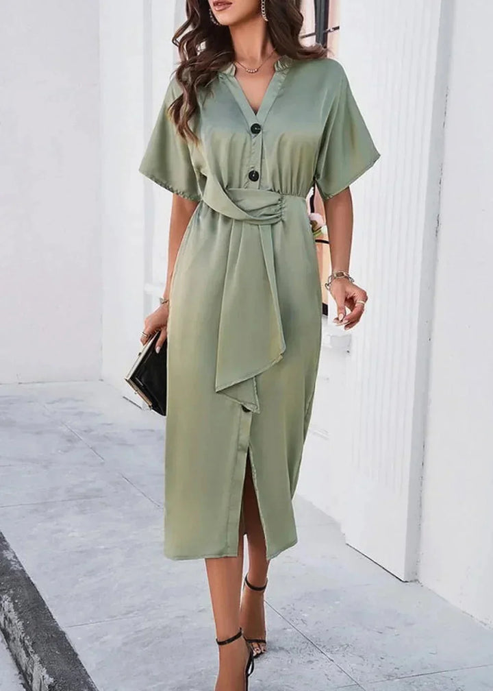 Sage green midi dress with V-neck, button detail, and a tie waist on a woman walking.