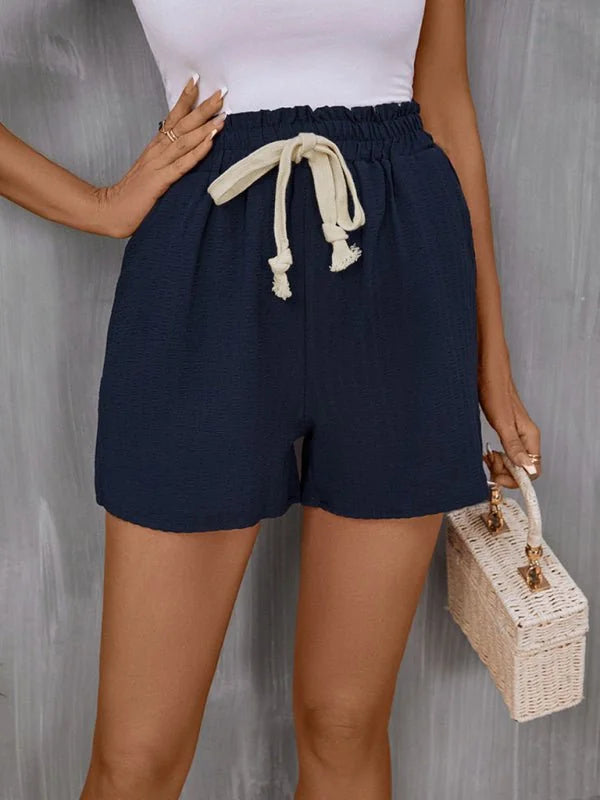 Navy blue textured shorts with drawstring waist and white rope tie detail.