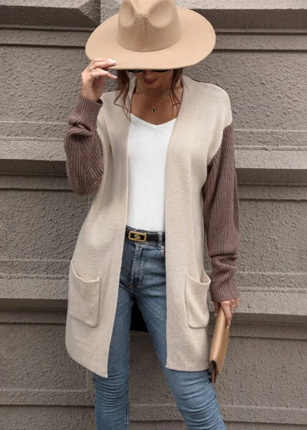 Beige and brown knit cardigan with pockets and a white top on a model.
