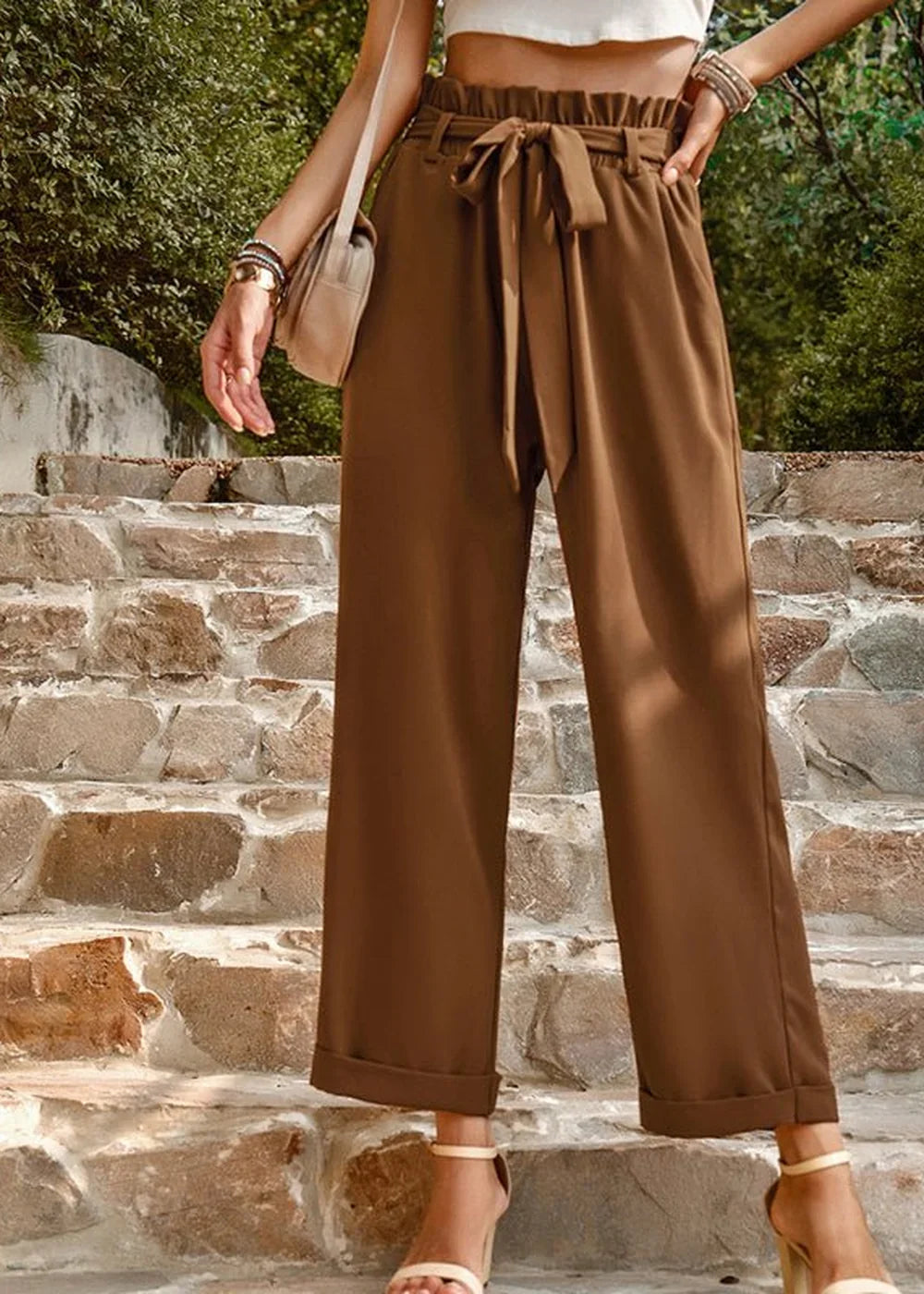 Brown wide-leg pants with a tie waist and cuffed hem, shown on a model.