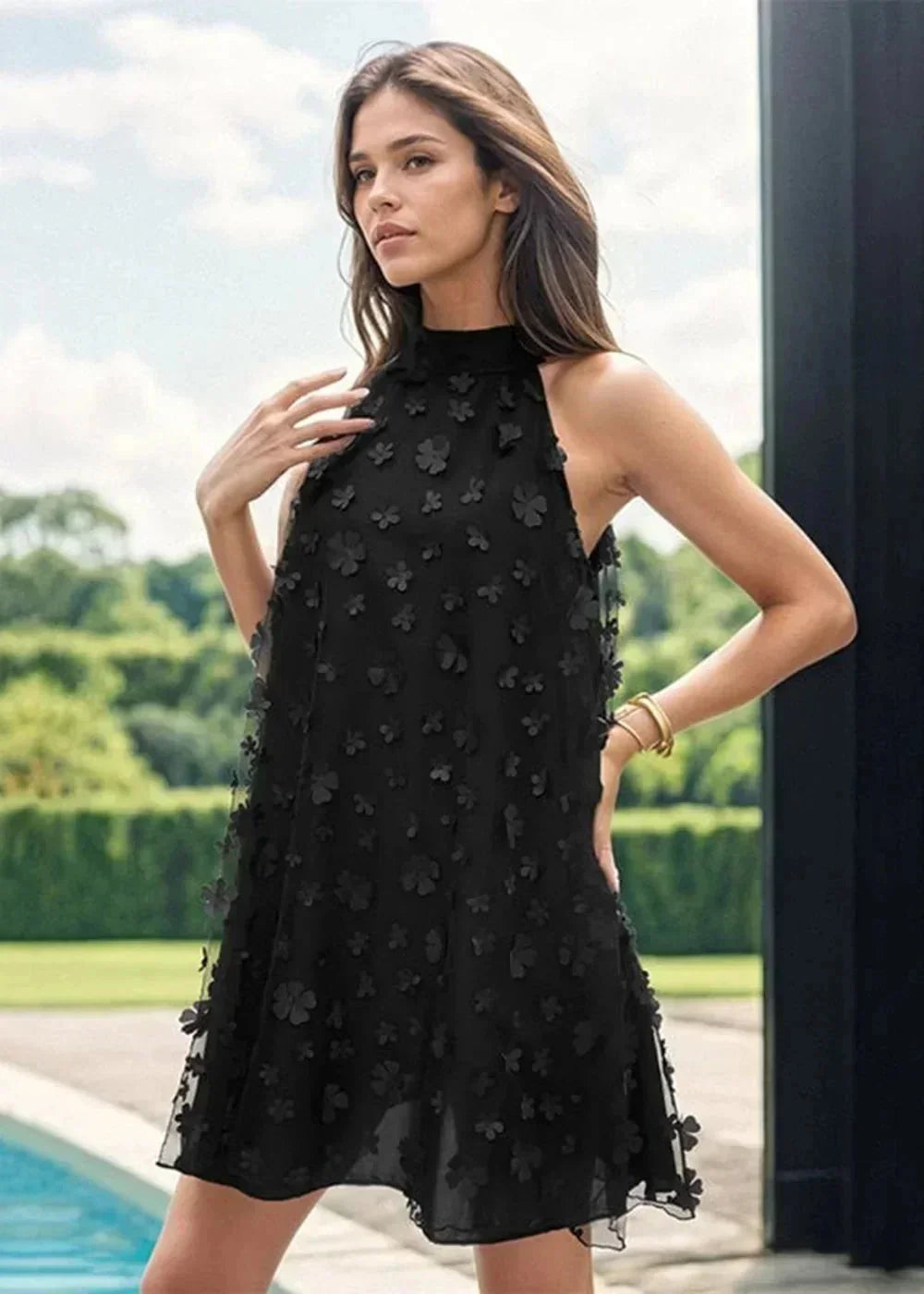 Black floral halter dress with a high neck, flowing A-line skirt, and textured appliqué flowers.
