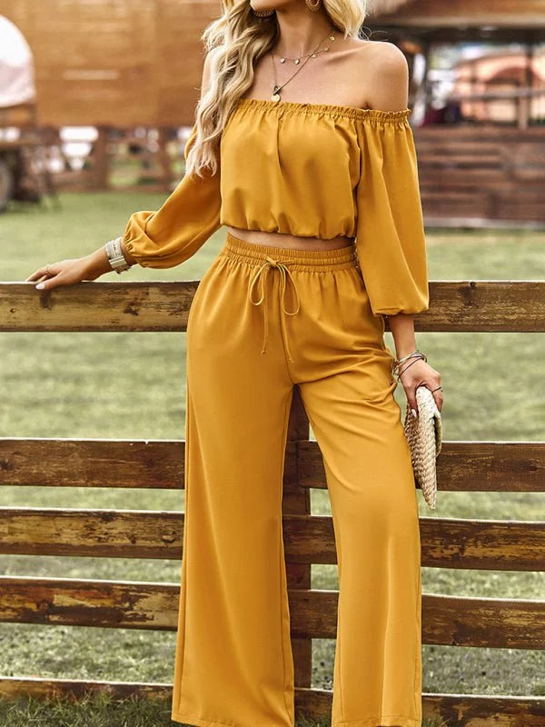 Mustard yellow off-the-shoulder crop top and wide-leg pants with drawstring waist on model.