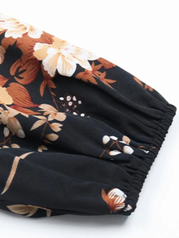 Close-up of a black polyester dress sleeve with a brown and cream floral print and elastic cuff.