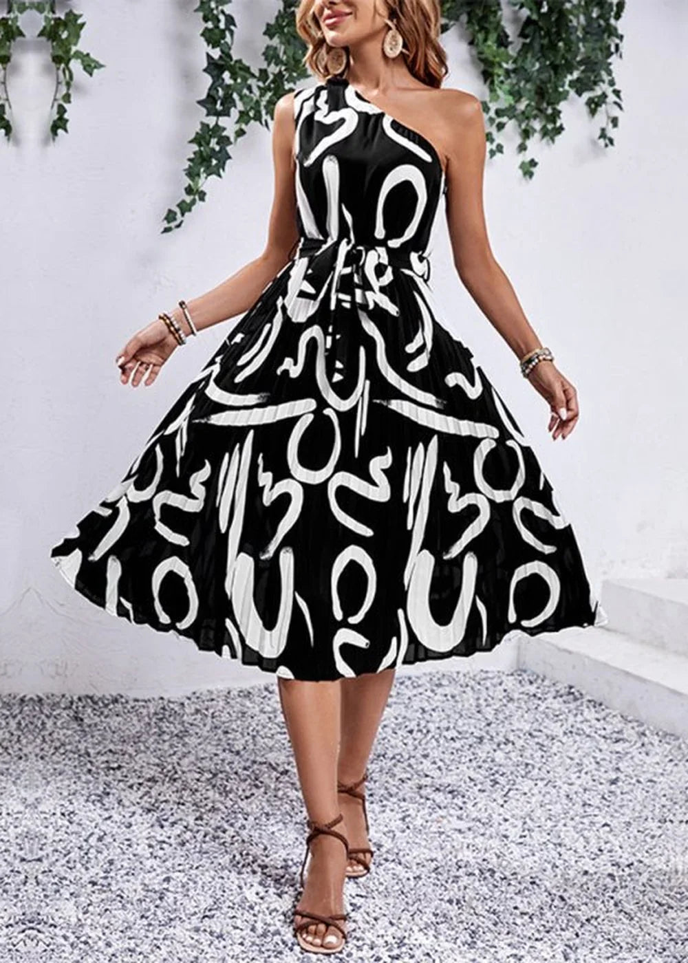 Black and white abstract print one-shoulder midi dress with tie waist and pleats.