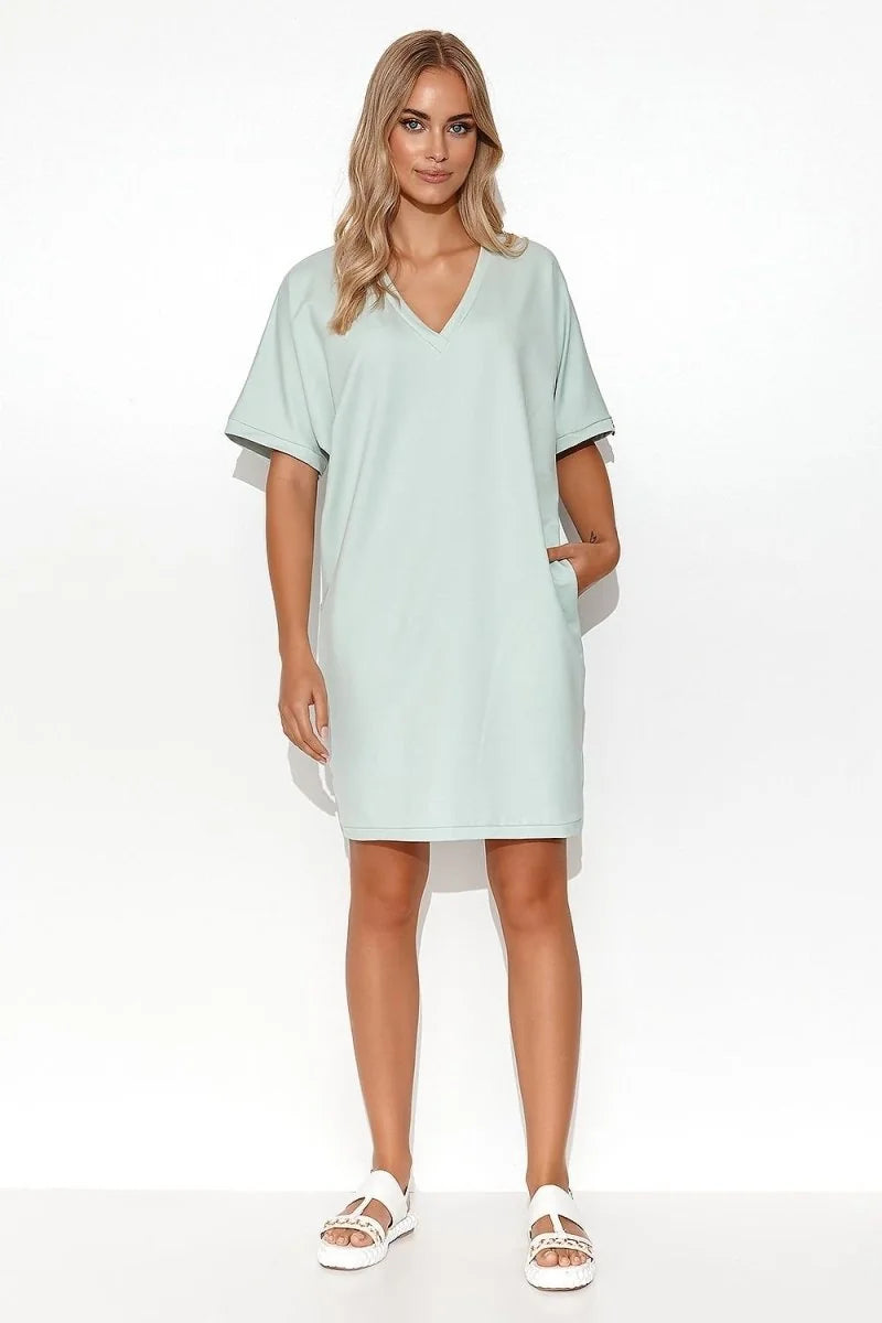 Light mint green V-neck cotton-blend dress with short sleeves and side pockets, worn by a model.