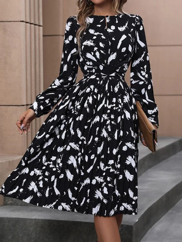 Black and white abstract print midi dress with long sleeves and pleated skirt.