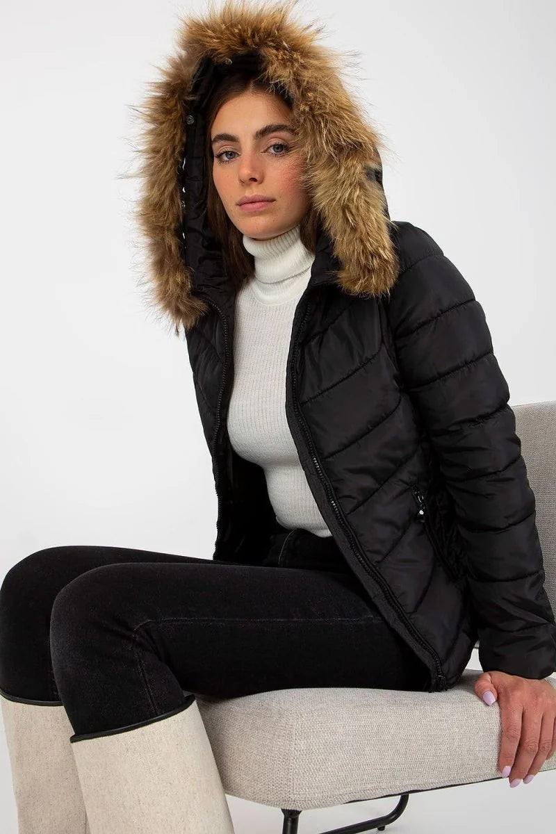 Black puffer jacket with fur-lined hood, worn over a white turtleneck and black jeans.