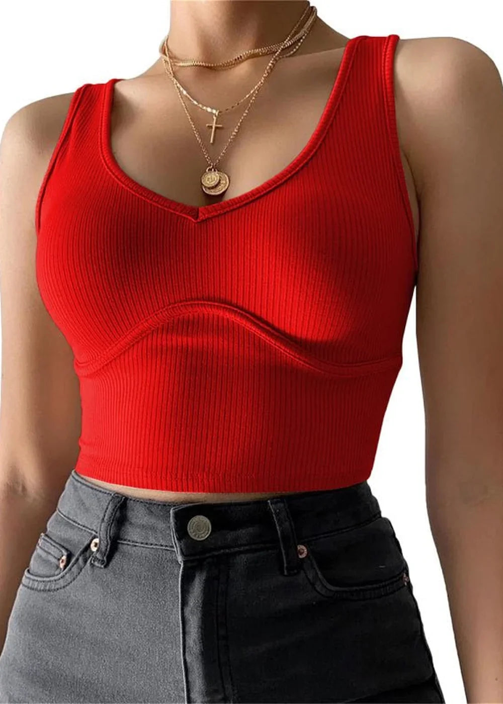 Red ribbed knit crop top with a V-neck and corset-style seams, paired with dark grey jeans.