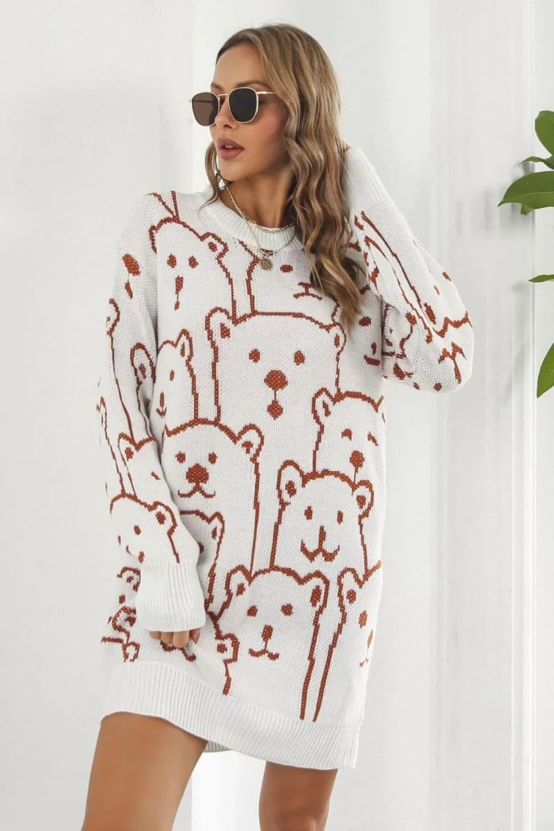 White knit sweater dress with a brown all-over bear pattern, long sleeves, and a crew neck, shown on a model.