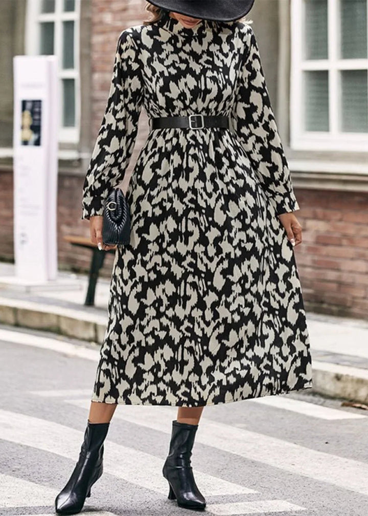 Black and cream abstract print midi dress with long sleeves, black belt, and black ankle boots.