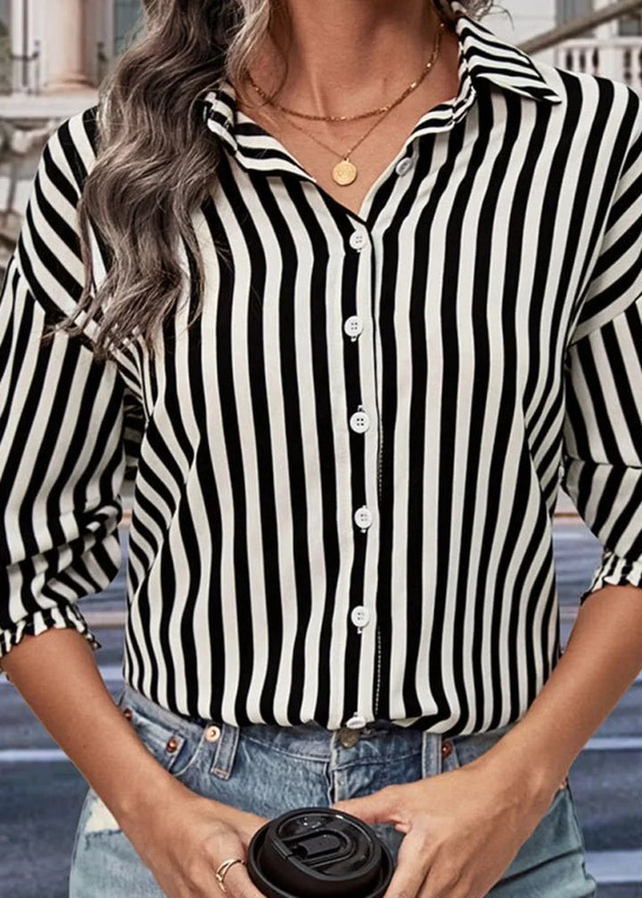 Black and white striped collared shirt with white buttons, on model.