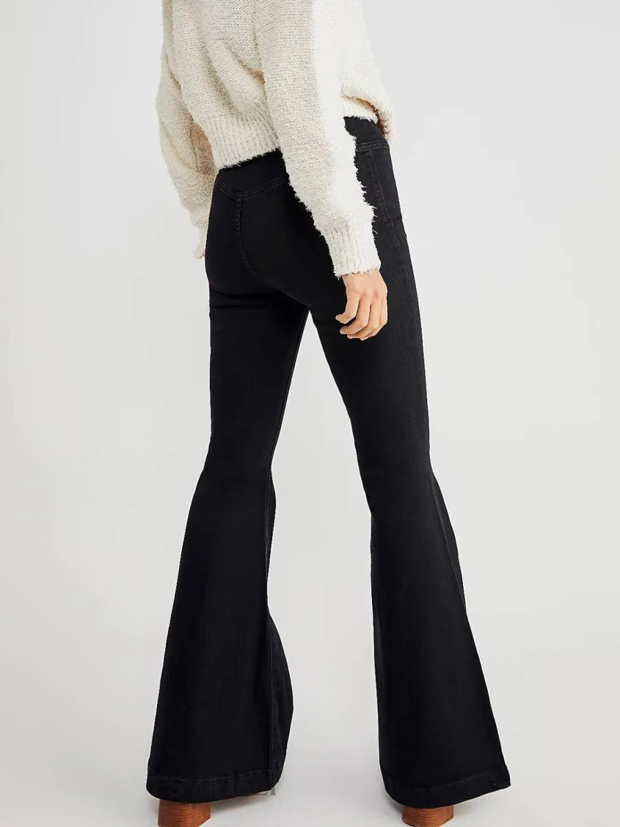 Black high-waisted flare jeans with a textured cream sweater, shown from the back.