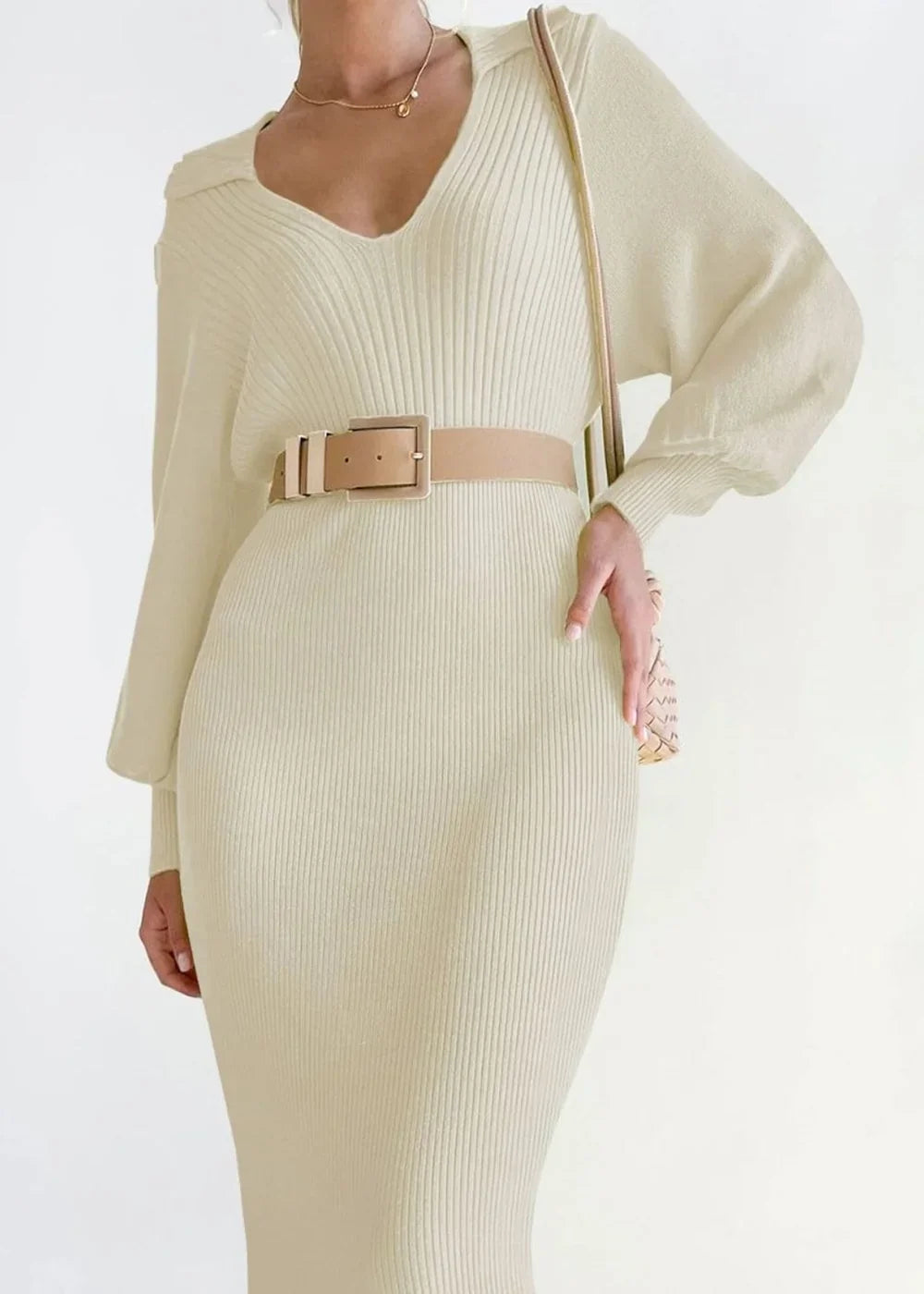 Cream ribbed knit sweater dress with V-neck, long sleeves, and a beige belt.