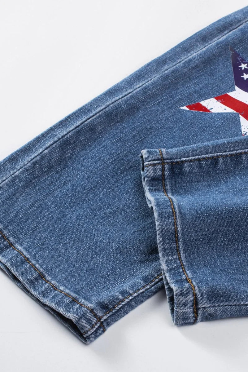 Close-up of blue denim jeans with an American flag star design and visible stitching.