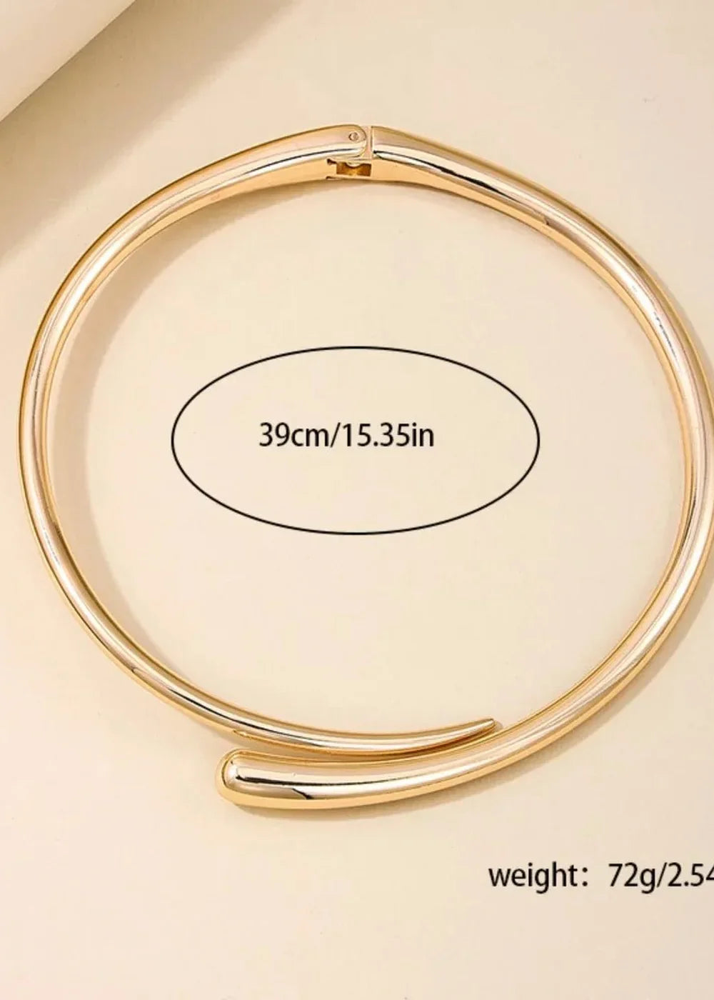 Gold-toned collar necklace with a smooth, polished finish and a clasp closure.
