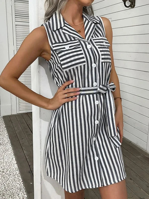 Sleeveless black and white striped shirt dress with a tie waist and button front, on a model.