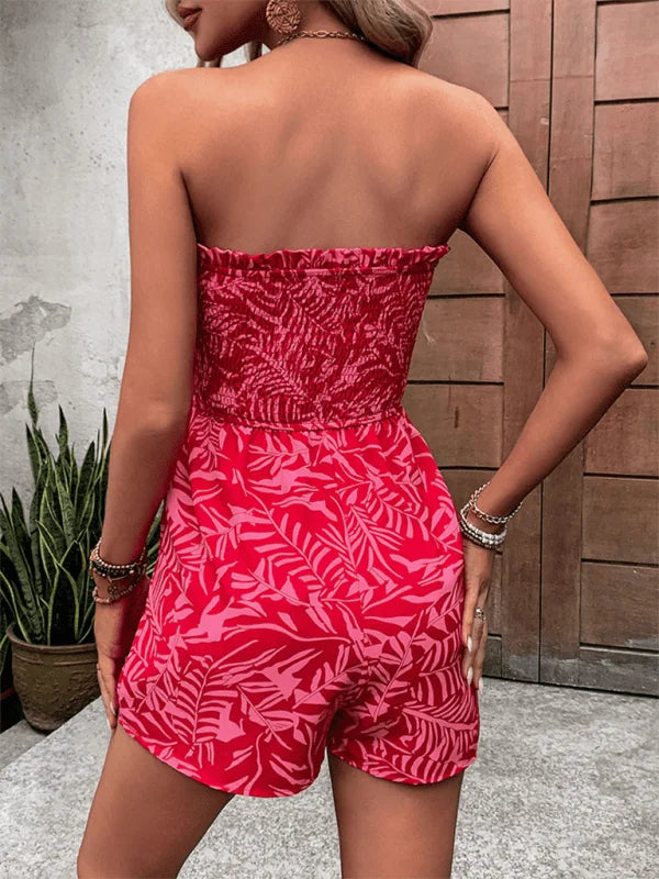 Red strapless romper with a vibrant pink tropical leaf print and smocked bodice.