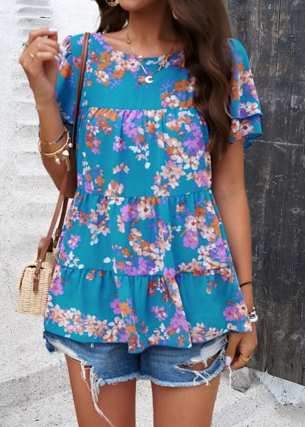 Teal chiffon tiered peasant top with orange and purple floral print, paired with distressed denim shorts.