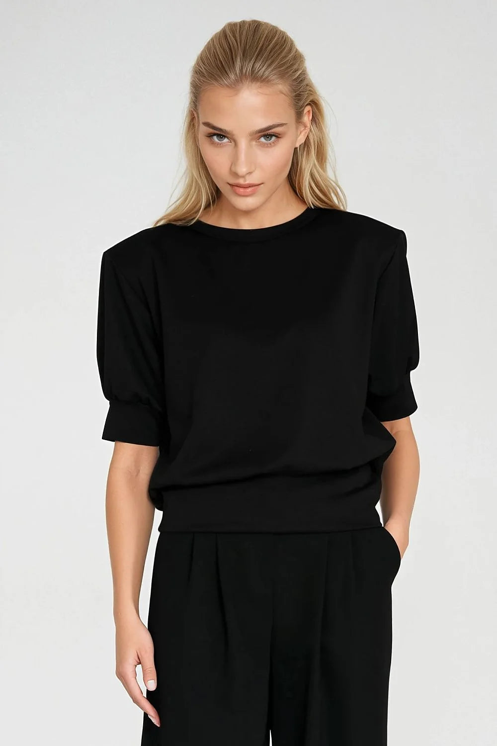 Black oversized sweatshirt with padded shoulders and gathered sleeves, worn by a model.