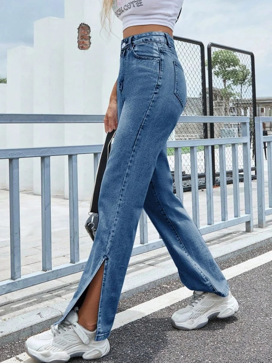 Medium wash denim jeans with high waist and thigh-high slits on legs.