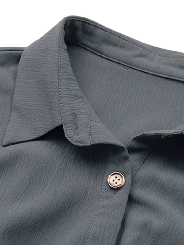 Close-up of a charcoal gray textured polyester dress with a button and collar detail.