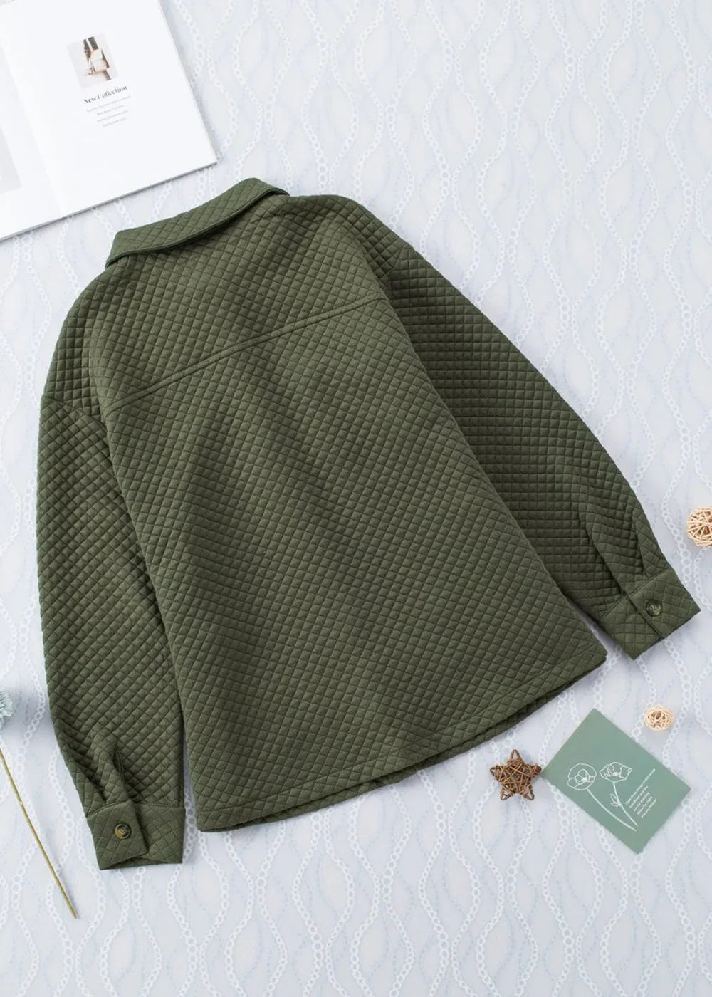 Olive green quilted jacket with a collared neckline and button cuffs, laid flat.