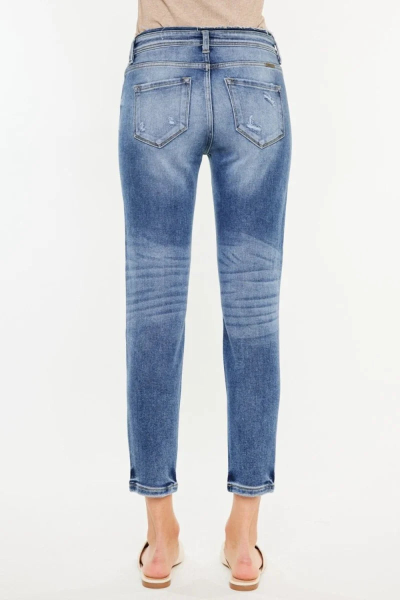 Distressed medium wash denim jeans with a slightly stretchy fit, showing the back view.