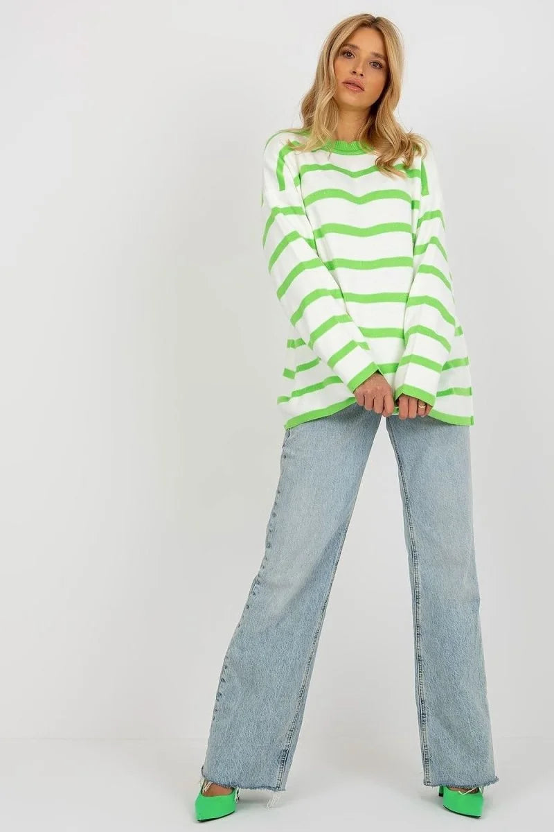 Relaxed fit acrylic and wool sweater with bright green and white horizontal stripes, worn by a model with light wash denim...