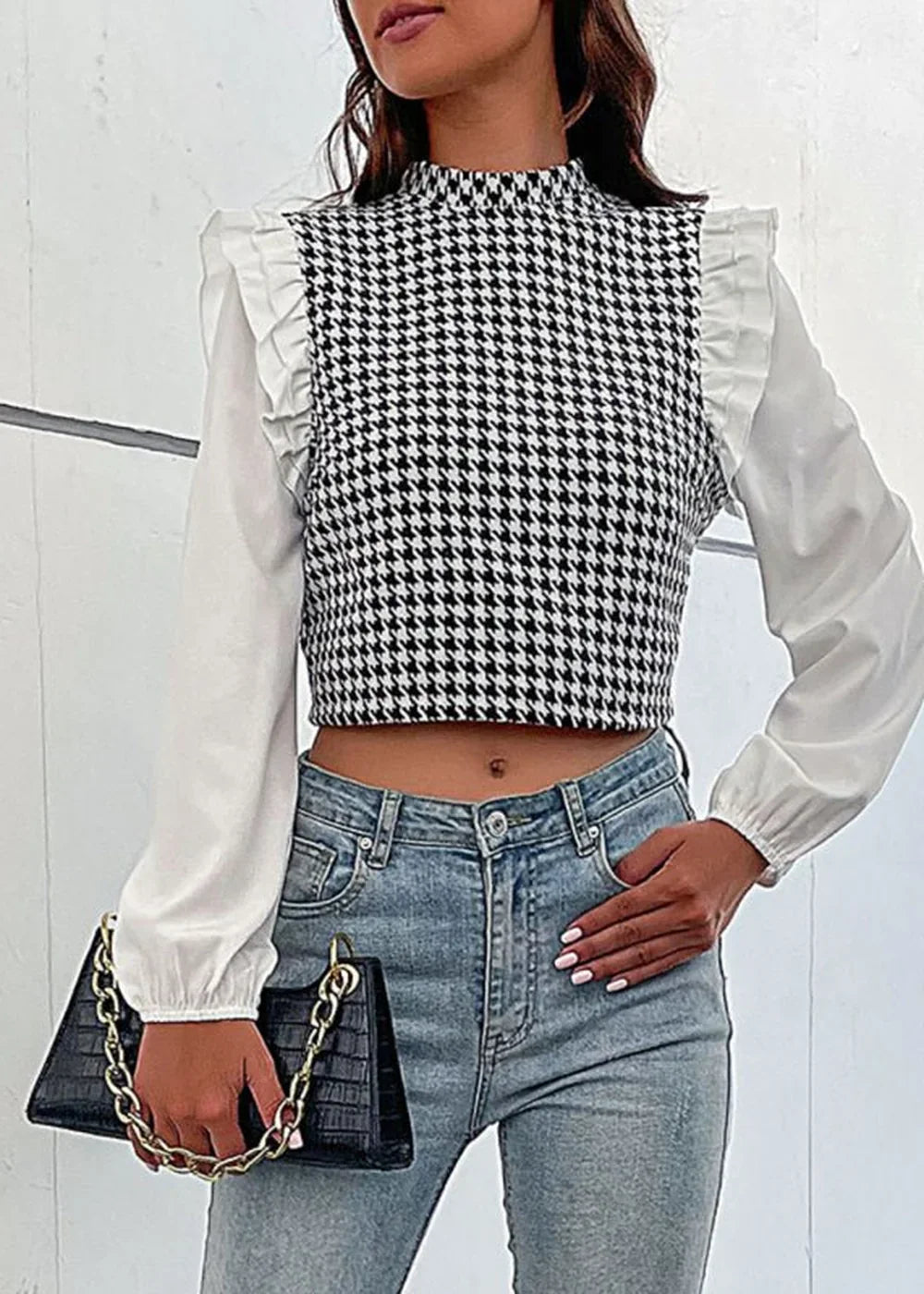 Black and white houndstooth crop top with ruffled white sleeves, paired with light wash jeans.