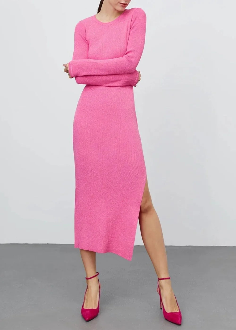 Bright pink ribbed knit sweater dress with a thigh-high slit, worn by a model with matching heels.