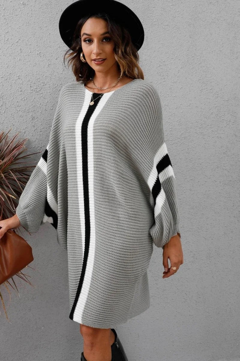 Gray knit sweater dress with vertical black and white stripes, balloon sleeves, and a fedora hat.