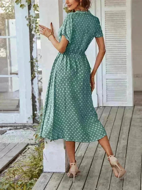 Green polka dot rayon dress with cinched waist and short sleeves, shown on a model from the back.