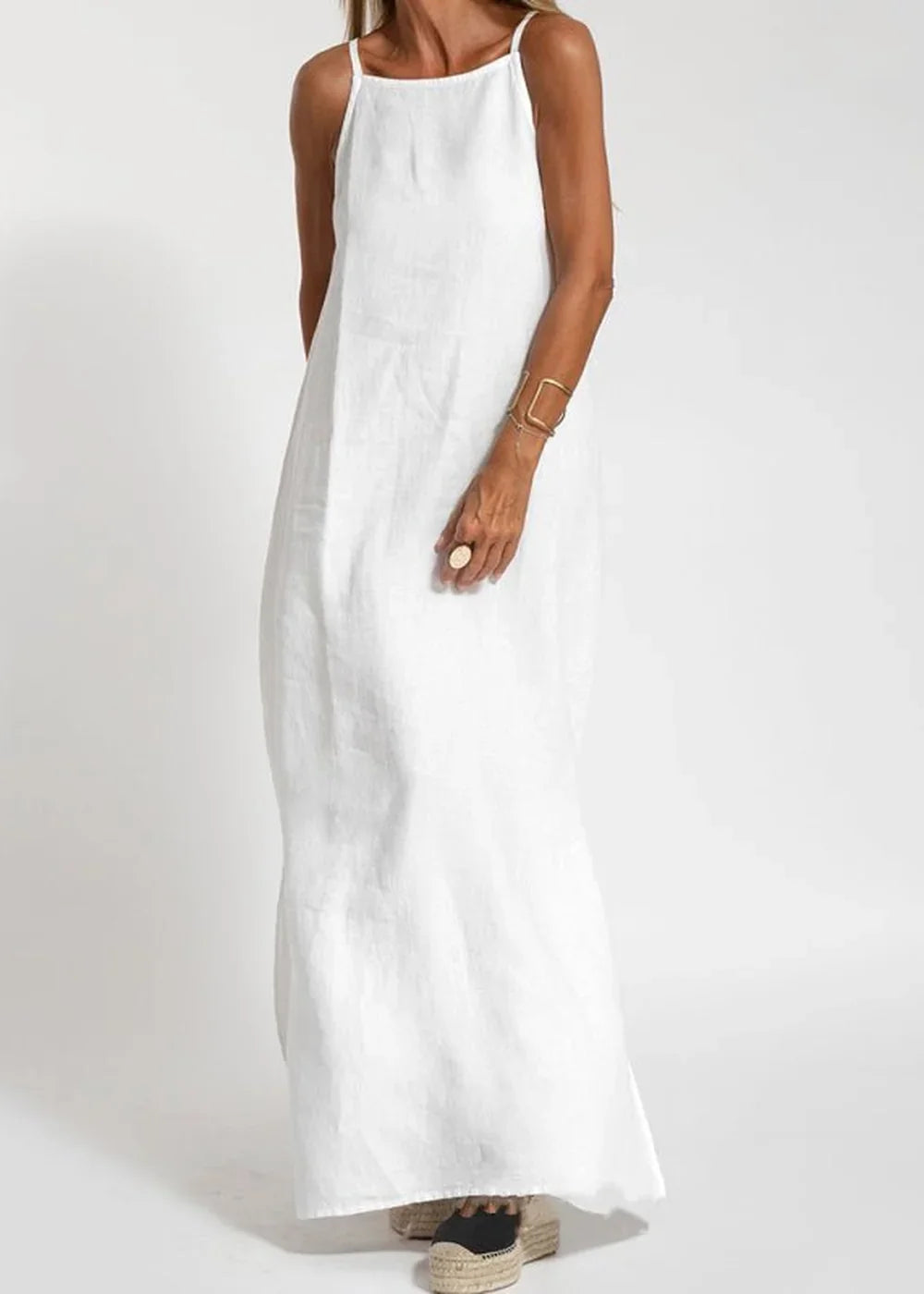 Full-length white linen-blend maxi dress with spaghetti straps and espadrille wedge shoes.