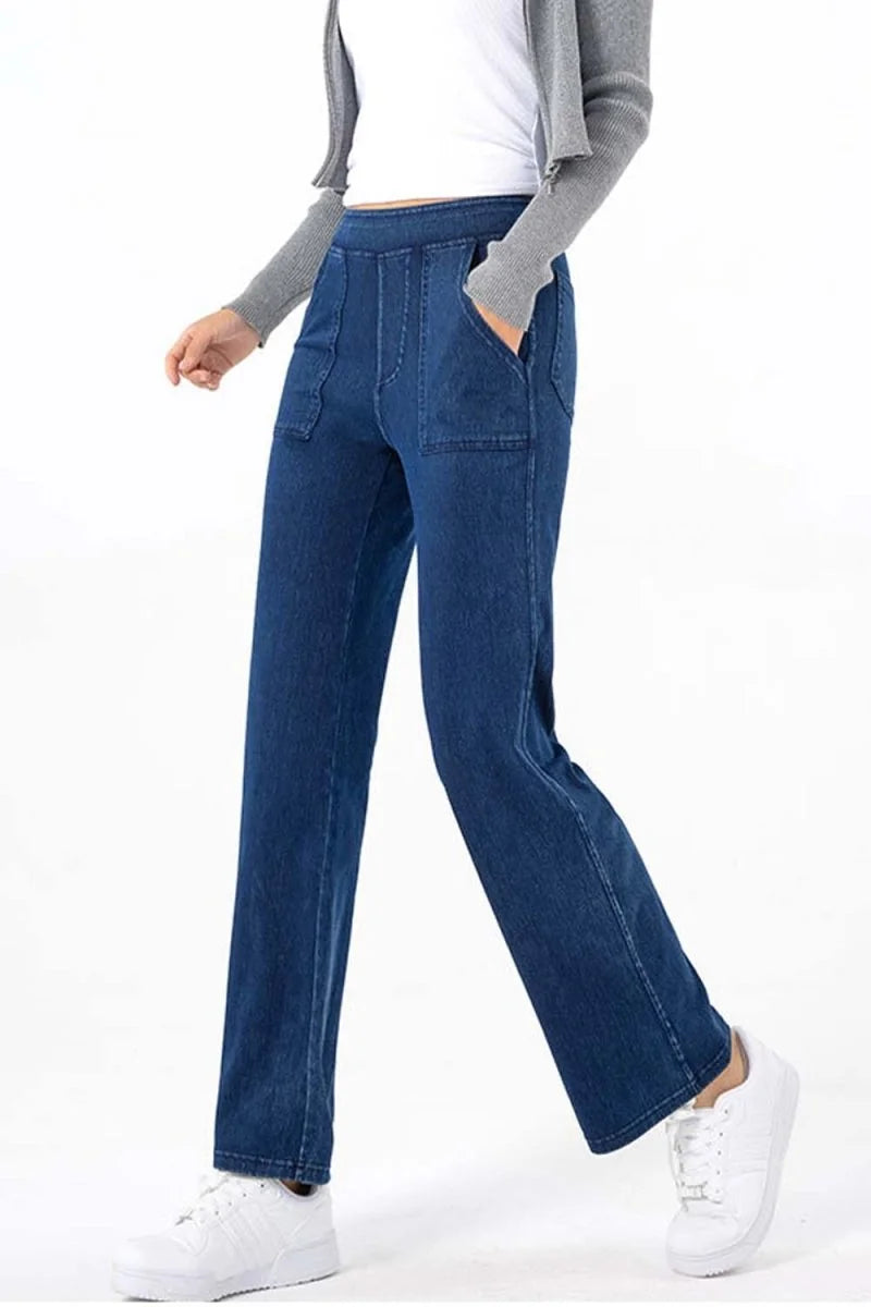 Model wearing wide-leg, dark wash denim jeans with front pockets and white sneakers.