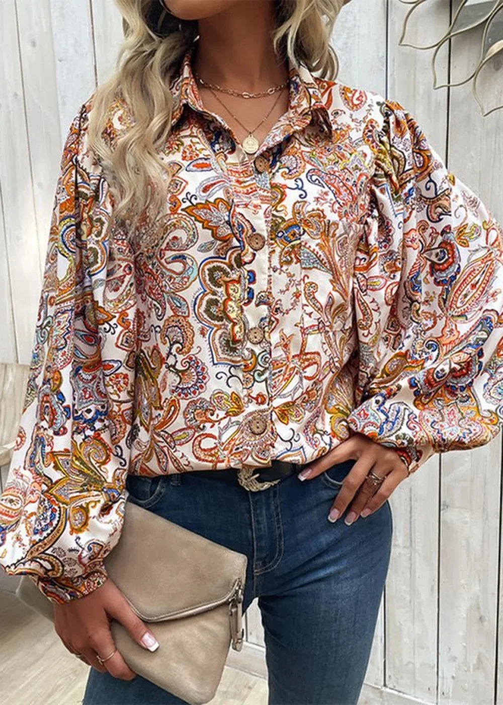 Loose fit white polyester blouse with a vibrant paisley print and balloon sleeves.