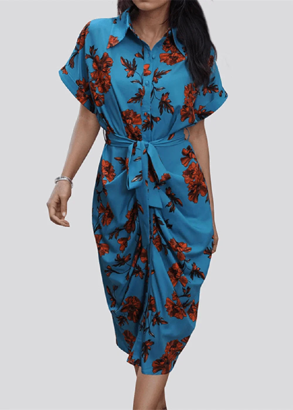 Blue dress with red floral print, tie waist, and draped skirt on a model.