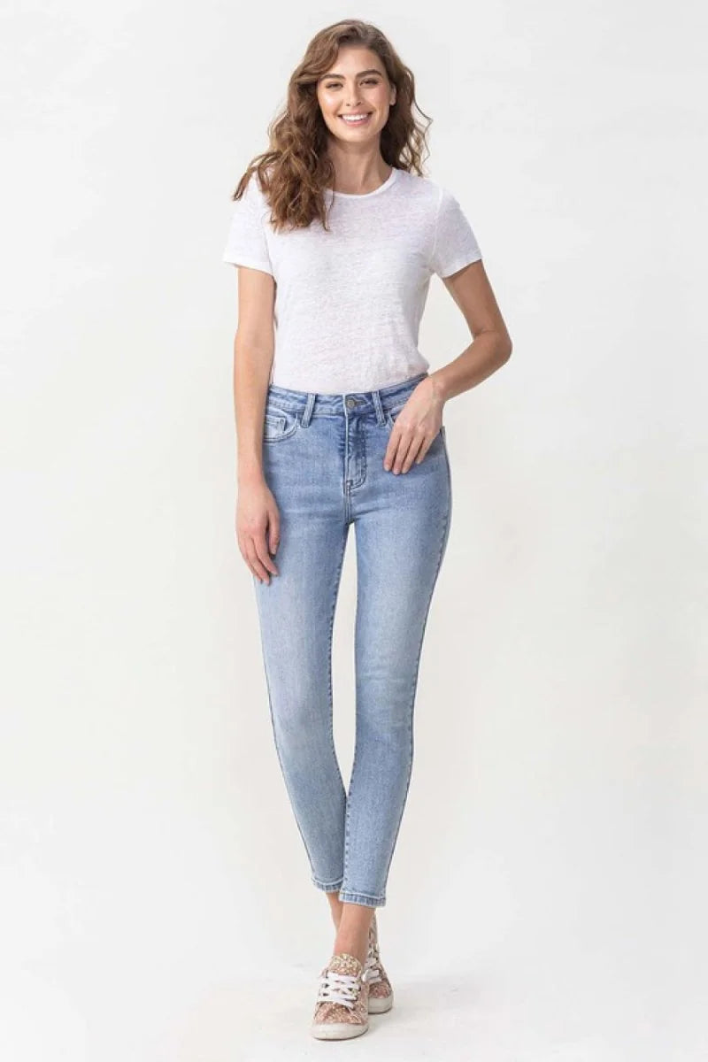 Light wash denim jeans with a high rise and skinny fit, on a model.