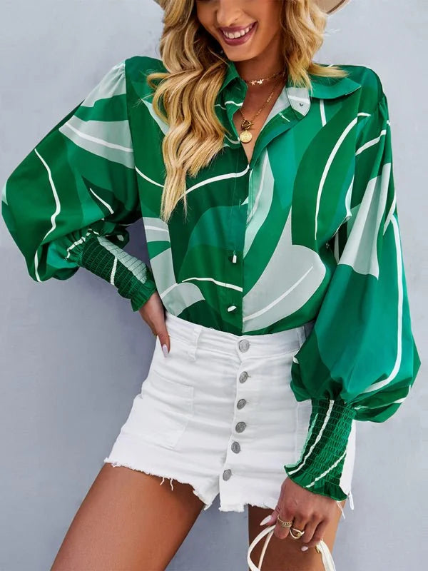 Green and white abstract print blouse with balloon sleeves and white denim shorts.