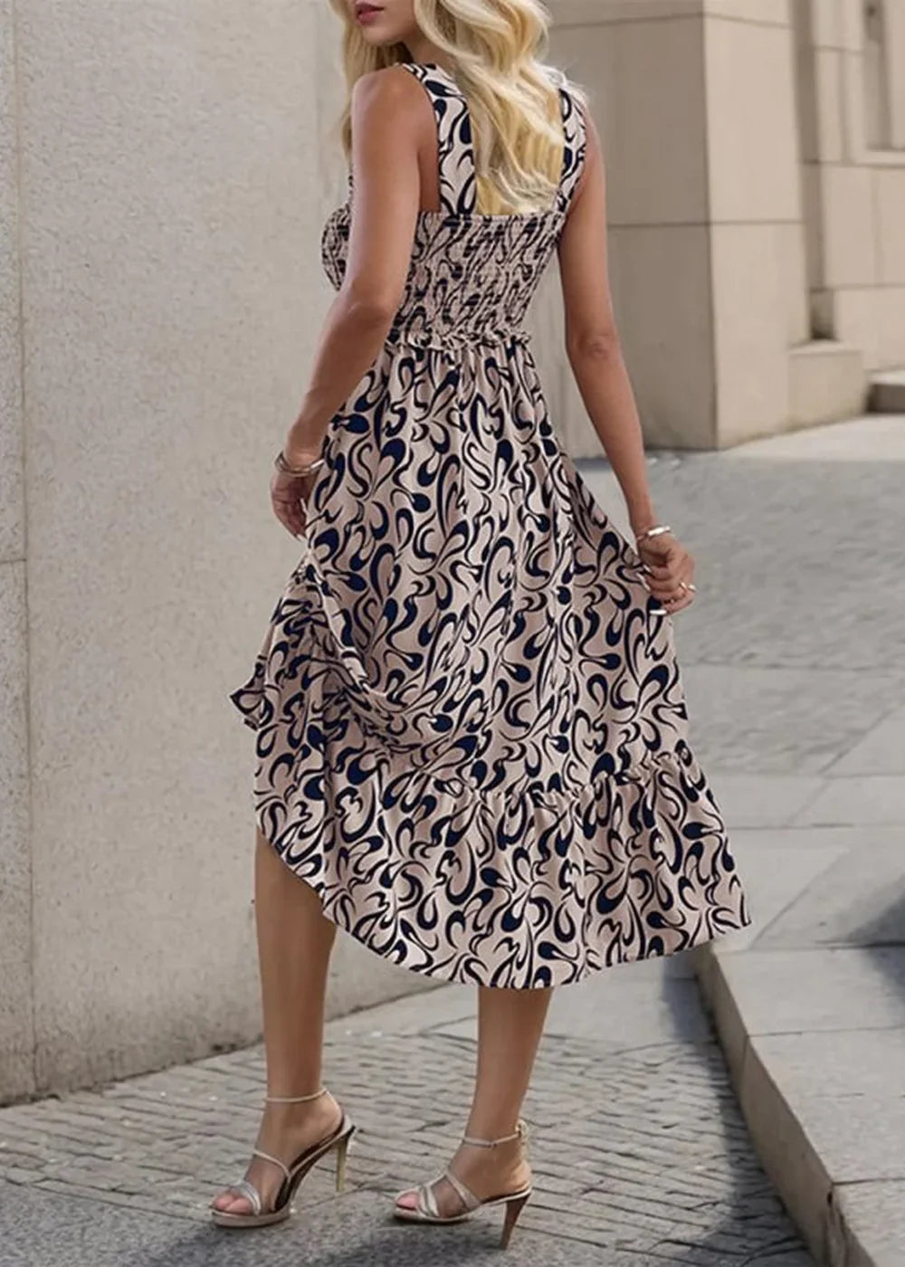 Beige and navy abstract print sleeveless midi dress with smocked bodice and ruffled hem.