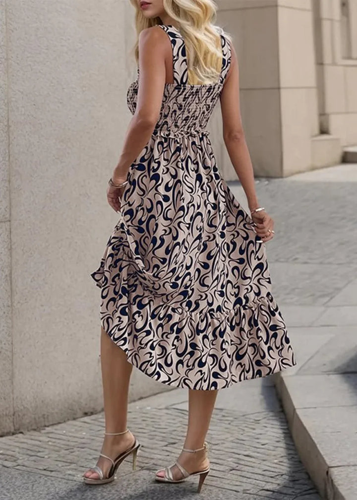 Beige and navy abstract print sleeveless midi dress with smocked bodice and ruffled hem.
