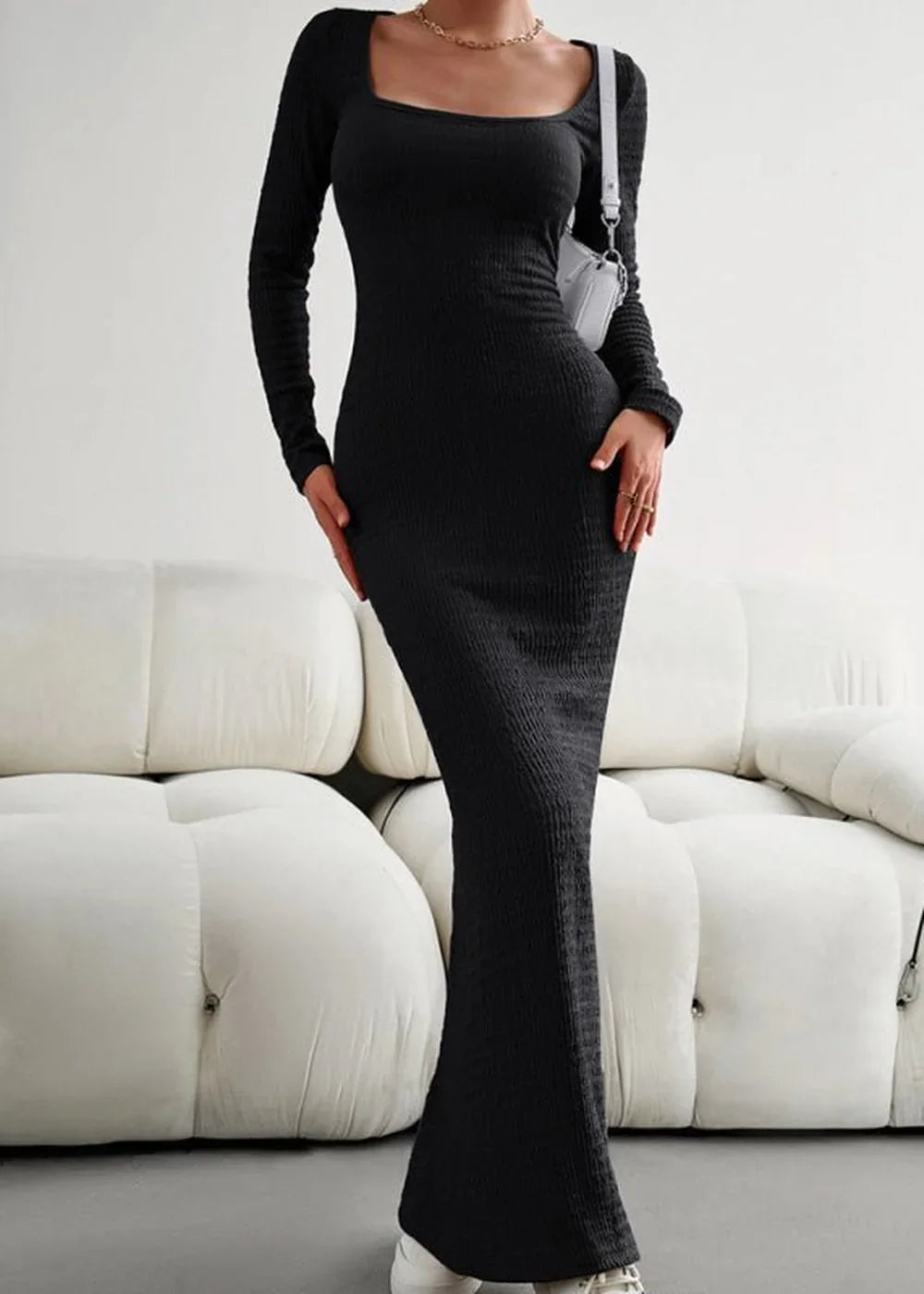 Black ribbed knit maxi dress with long sleeves and a square neckline, worn by a model.