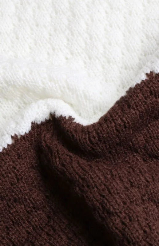 Close-up of a knit sweater with alternating white and brown sections and a textured weave.