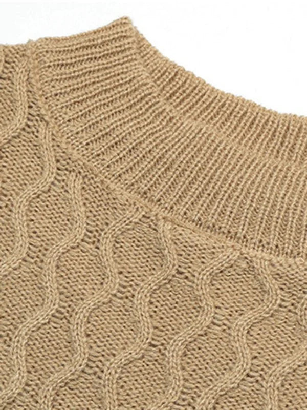 Close-up of a tan knit sweater with a cable knit pattern and ribbed neckline.