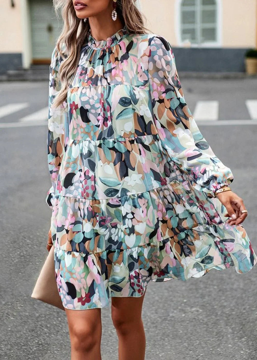 Flowy tiered mini dress with a vibrant abstract floral print in shades of pink, green, and blue.