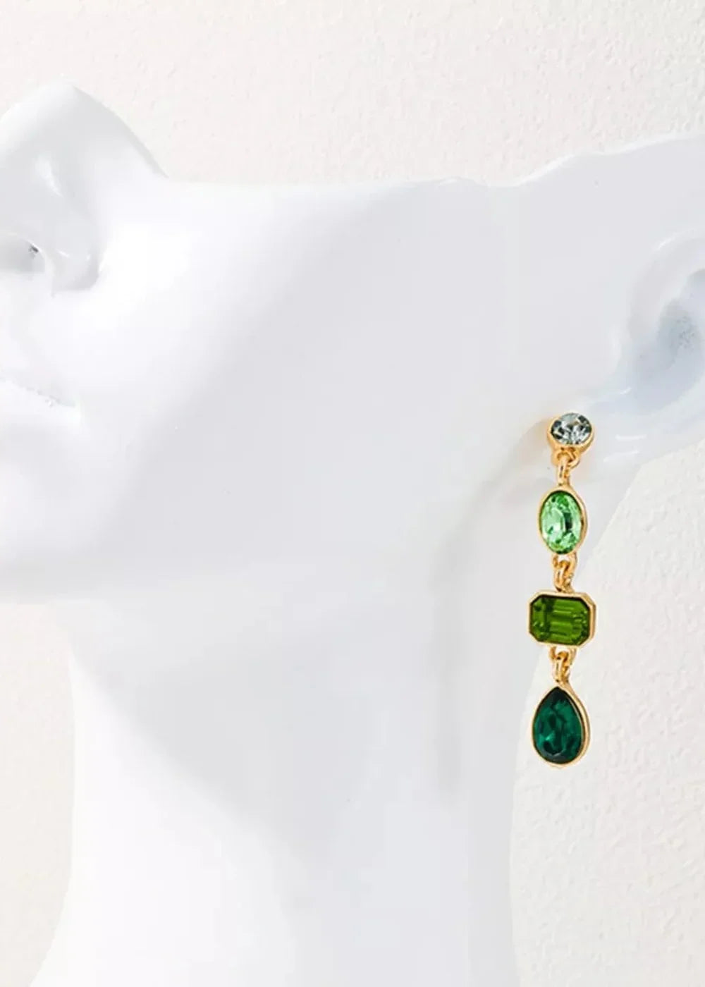 Gold-plated dangle earring with gradient green acrylic gems on a white bust.