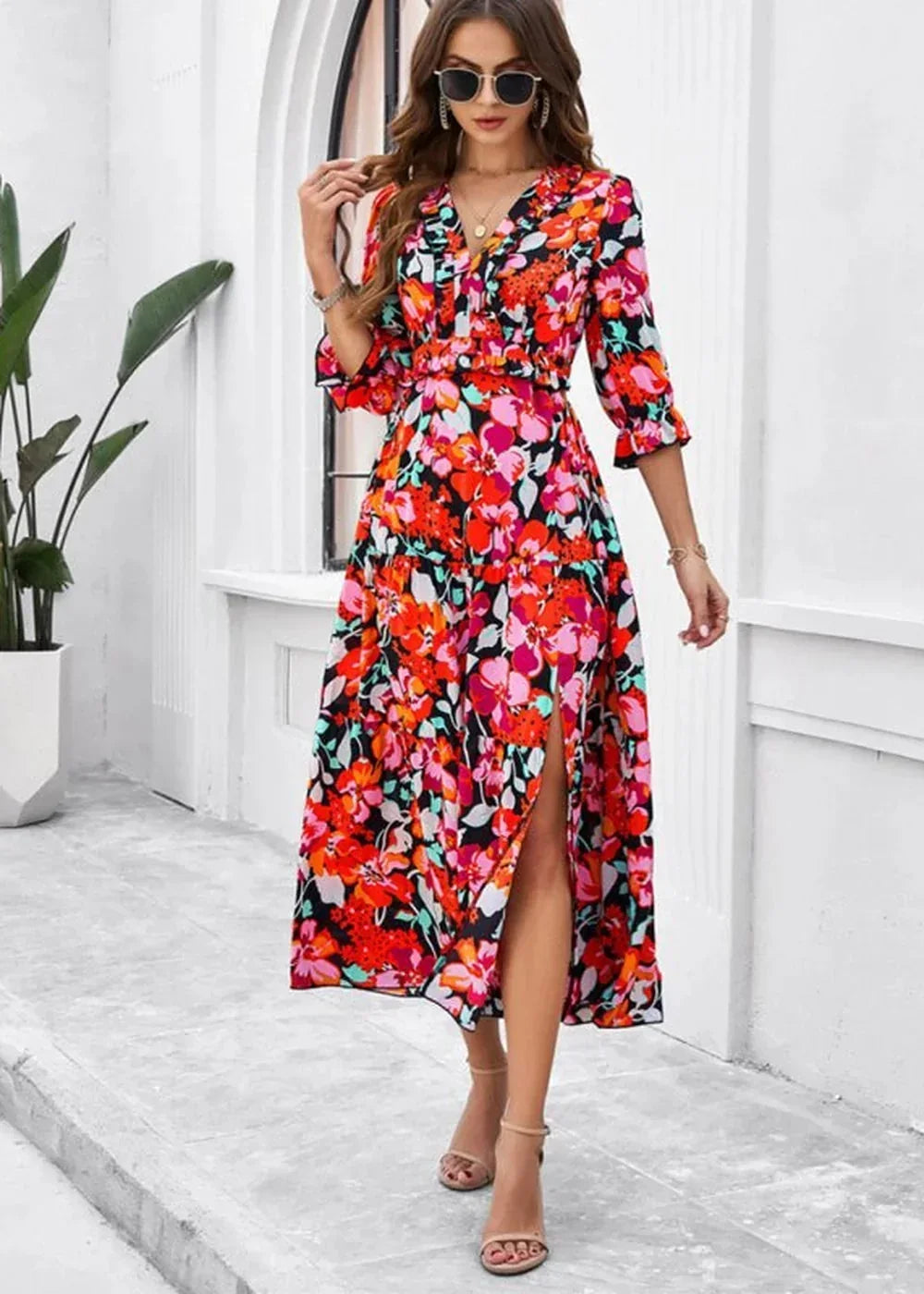 A vibrant floral print maxi dress with a V-neck and a thigh-high slit.