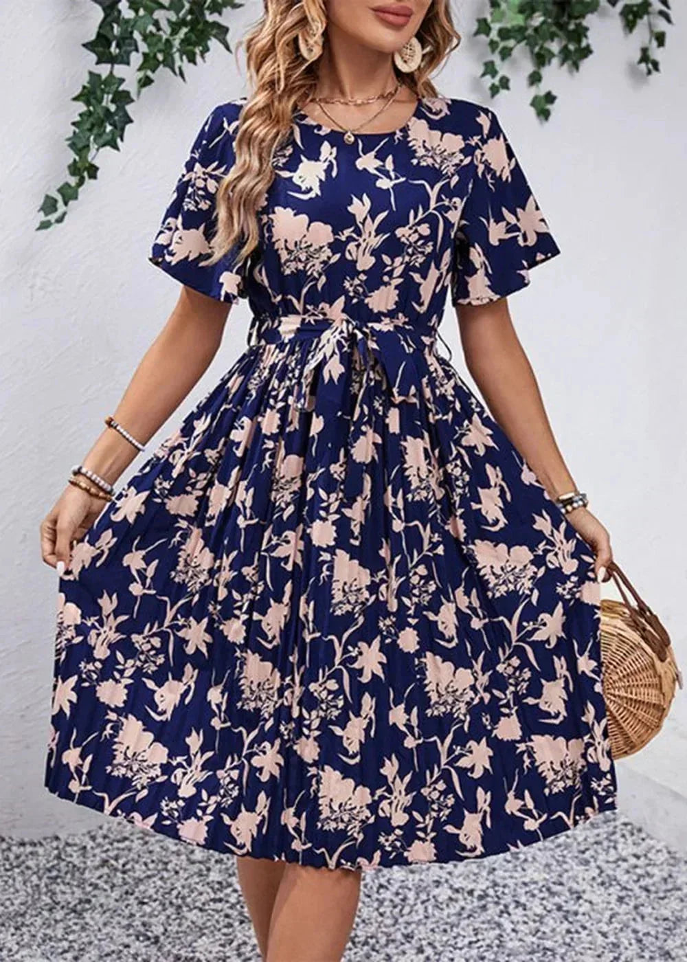 Navy blue midi dress with a pink floral print, short flutter sleeves, and a tie waist.
