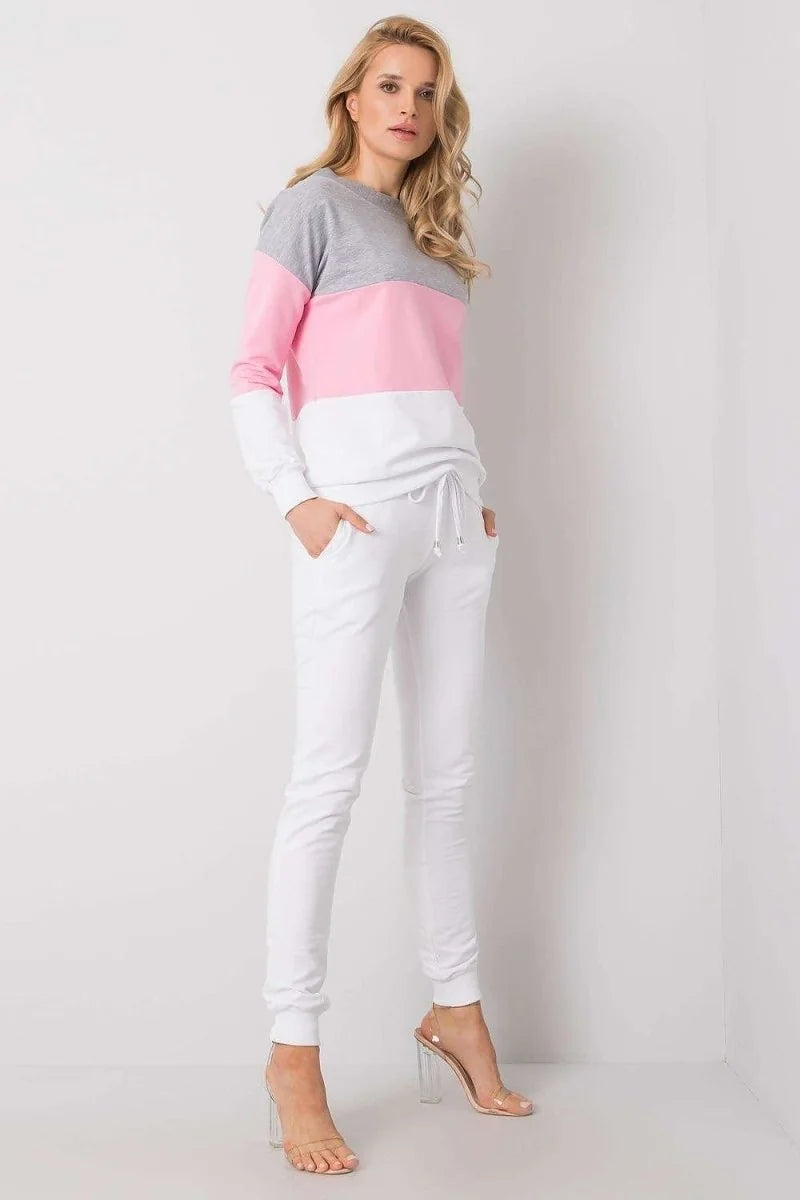 Full-length shot of a woman wearing white sweatpants with a drawstring waist and clear block heels.