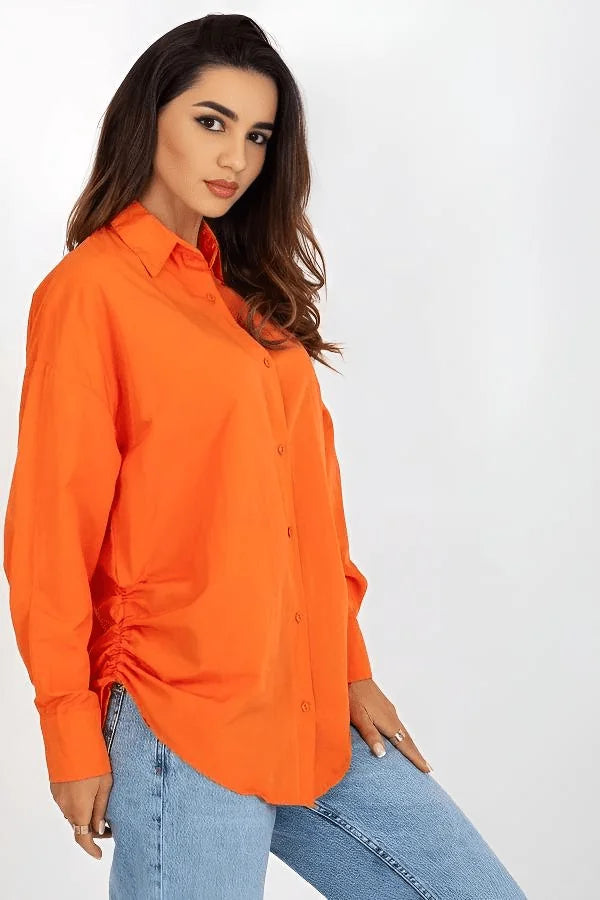 Orange oversized cotton-blend shirt with ruched side detail, on a model wearing light blue jeans.