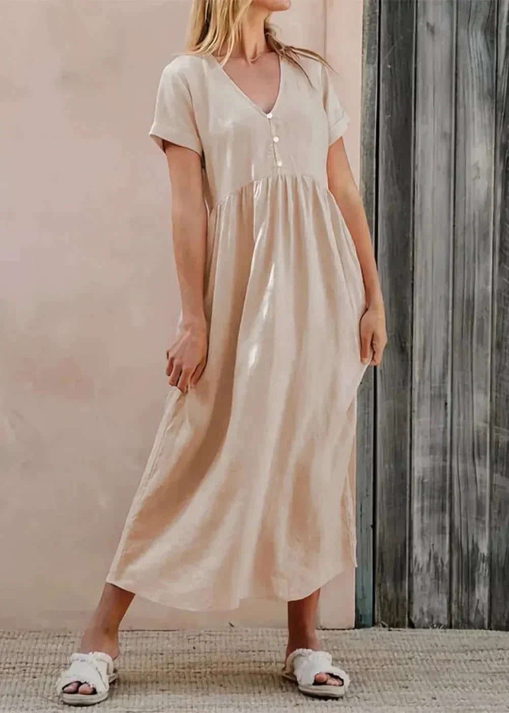 Cream cotton midi dress with V-neck, short sleeves, and button detail, on model.